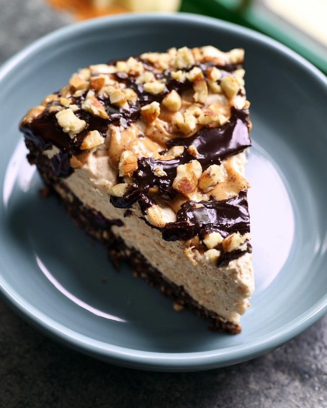 Keto Peanut Butter Pie - A sliced portion of chocolate mascarpone peanut butter pie on a blue plate, featuring a creamy filling, dark crust, and crunchy topping