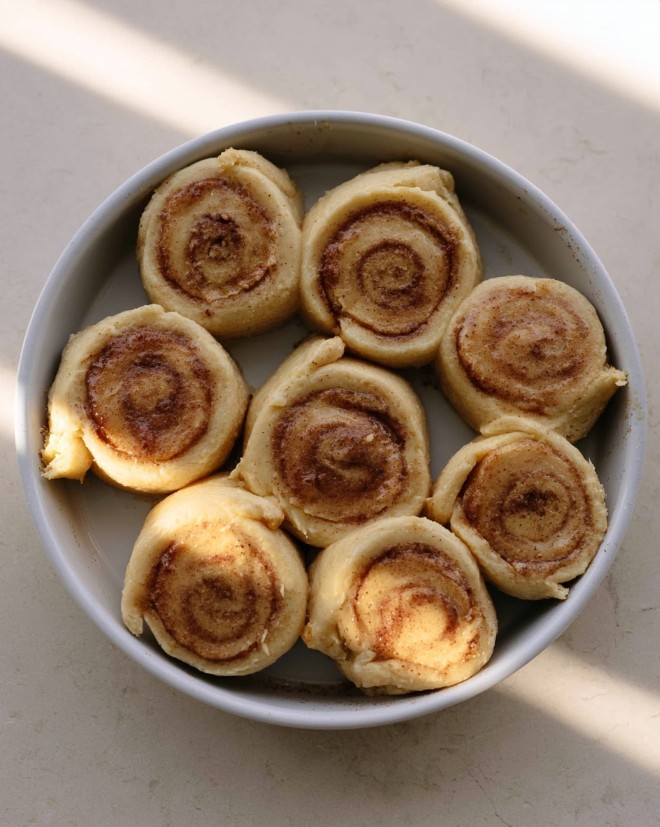 Keto Cinnamon Rolls - Sliced almond flour dough arranged in a circular baking dish, showing clear cinnamon swirls before baking