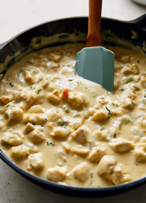 Keto Chicken Pot Pie Filling - golden chicken pieces and tender vegetables simmering in a rich, creamy sauce inside a black skillet