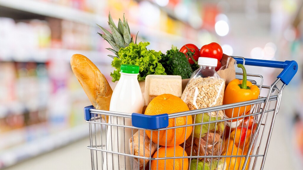 Shopping cart filled with fresh produce, bread, oats, dairy, and Mediterranean diet grocery staples.