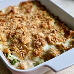 Baked chicken and broccoli Alfredo casserole with a golden brown cheese crust in a white dish