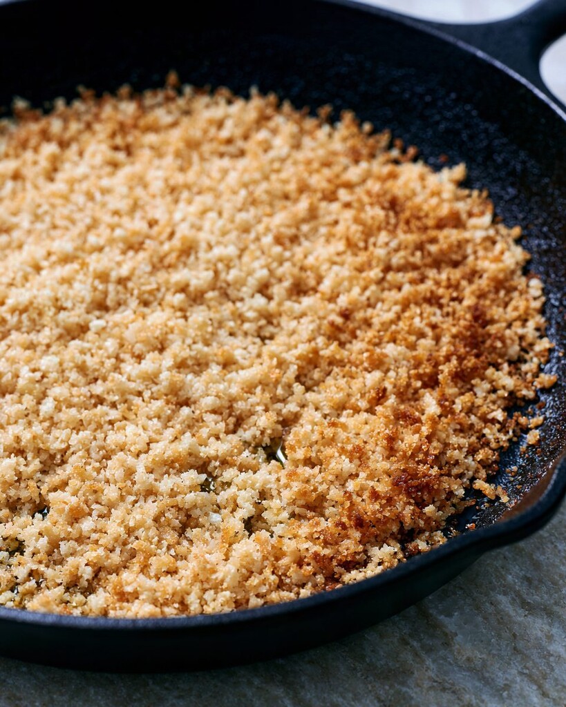 Garlic panko toasting in a black cast iron skillet