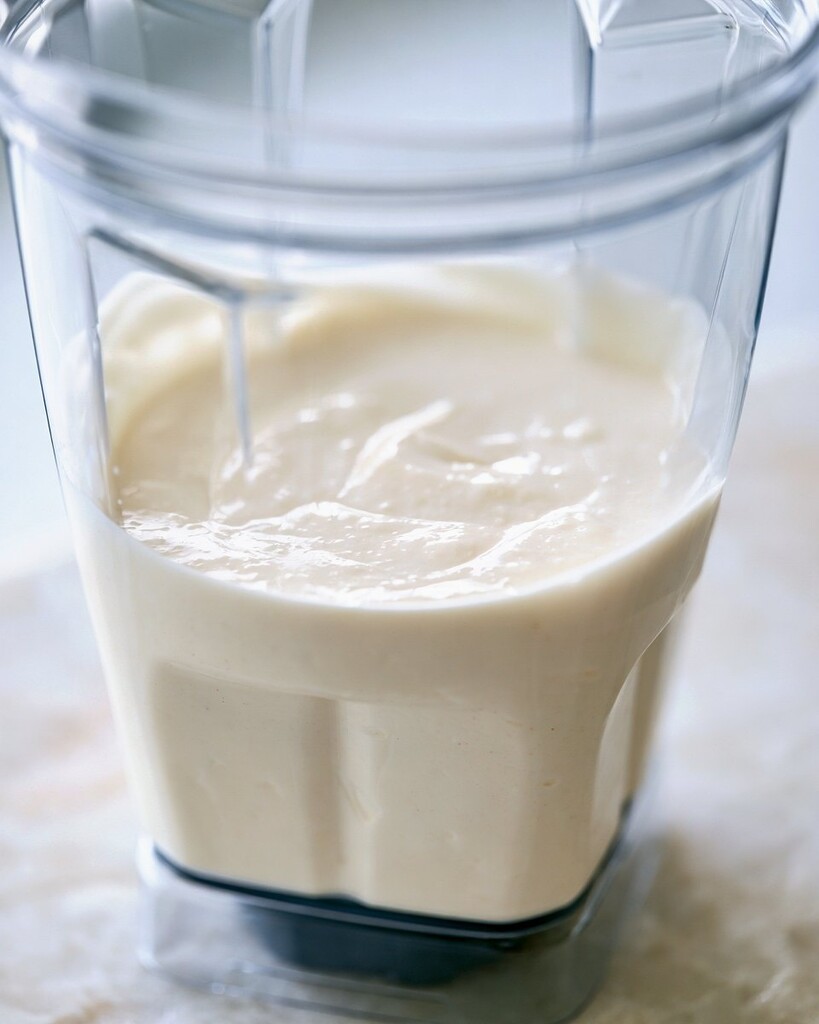 Smooth pale protein muffin batter inside a clear blender jar