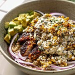 Sliced dark chicken and creamy corn salad served over a base of quinoa
