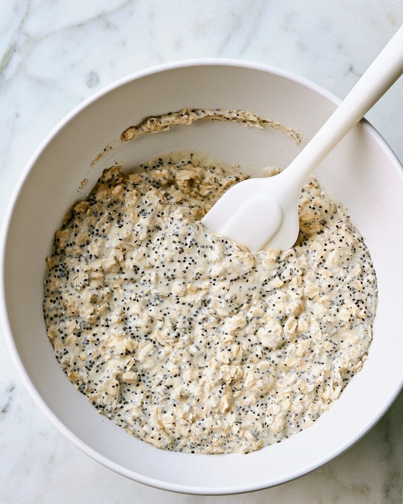 Rolled oats and chia seeds mixed with peanut butter and milk in a white bowl