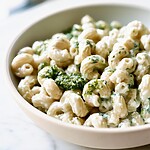 Pesto-Swirled Cottage Cheese Macaroni That Won't Clump Cavatappi pasta coated in a creamy white cottage cheese sauce with green pesto swirls in a serving bowl