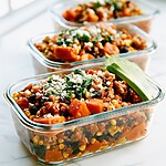 Smoky turkey and sweet potato meal prep bowls in glass containers topped with cheese