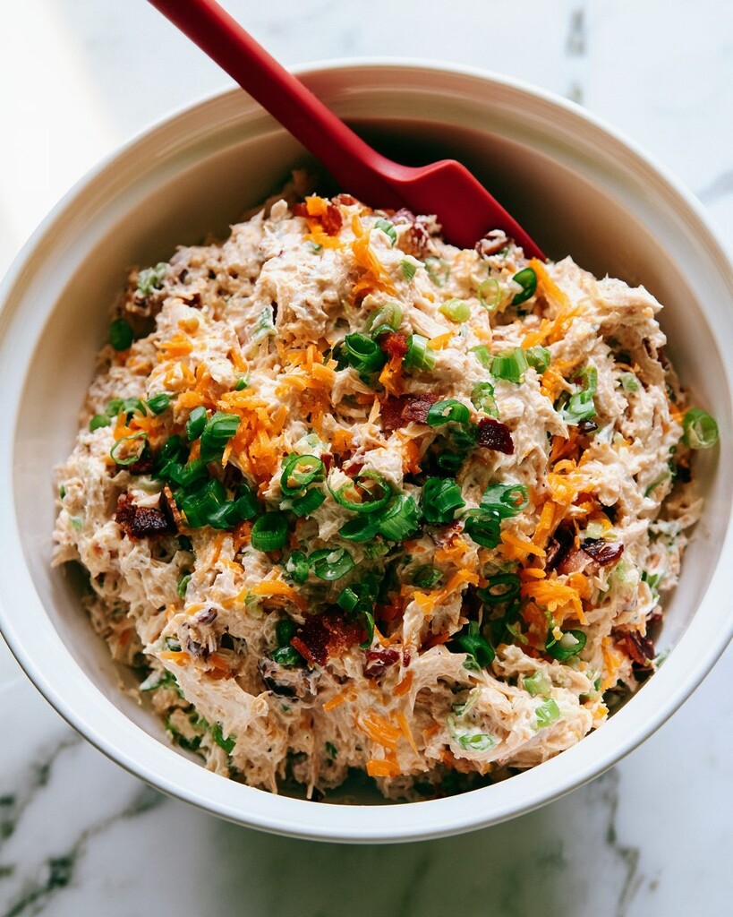 creamy crack chicken slider filling mixed with bacon and green onions in a bowl