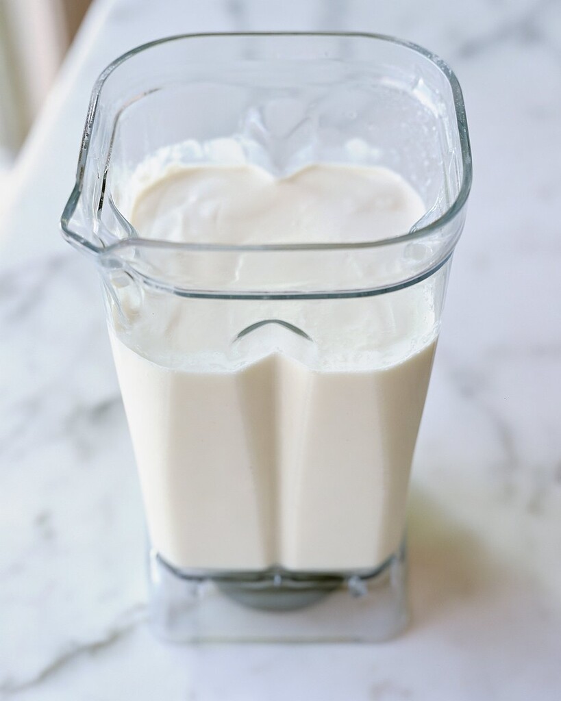Smooth, liquid white cheese sauce base inside a blender pitcher
