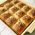 Crack Chicken Sliders (No Soggy Buns) baked crack chicken sliders in a ceramic dish topped with toasted everything bagel seasoning