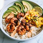 Chili-spiced shrimp bowl arranged with seared shrimp, sliced avocado, mango salsa, and jasmine rice