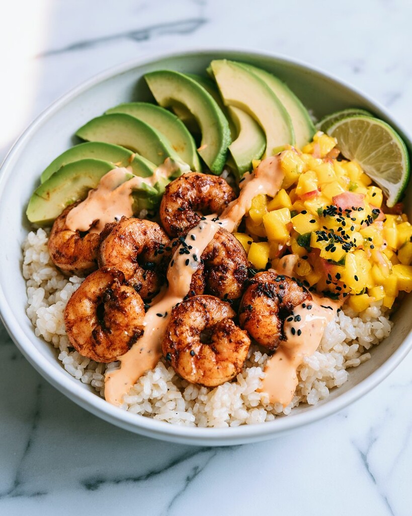 Chili-spiced shrimp bowl arranged with seared shrimp, sliced avocado, mango salsa, and jasmine rice