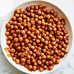 Smoky paprika and garlic roasted chickpeas served on a wide white plate with a dark crust