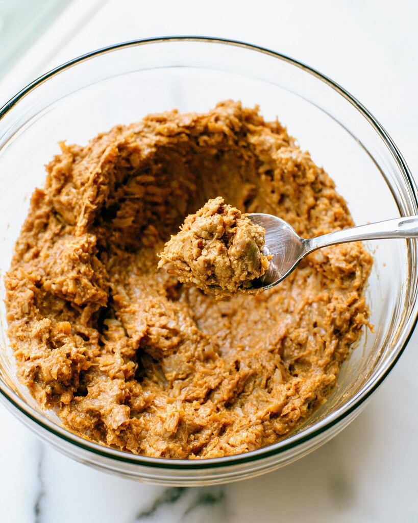 Thick almond butter and toasted coconut paste mixed in a glass bowl