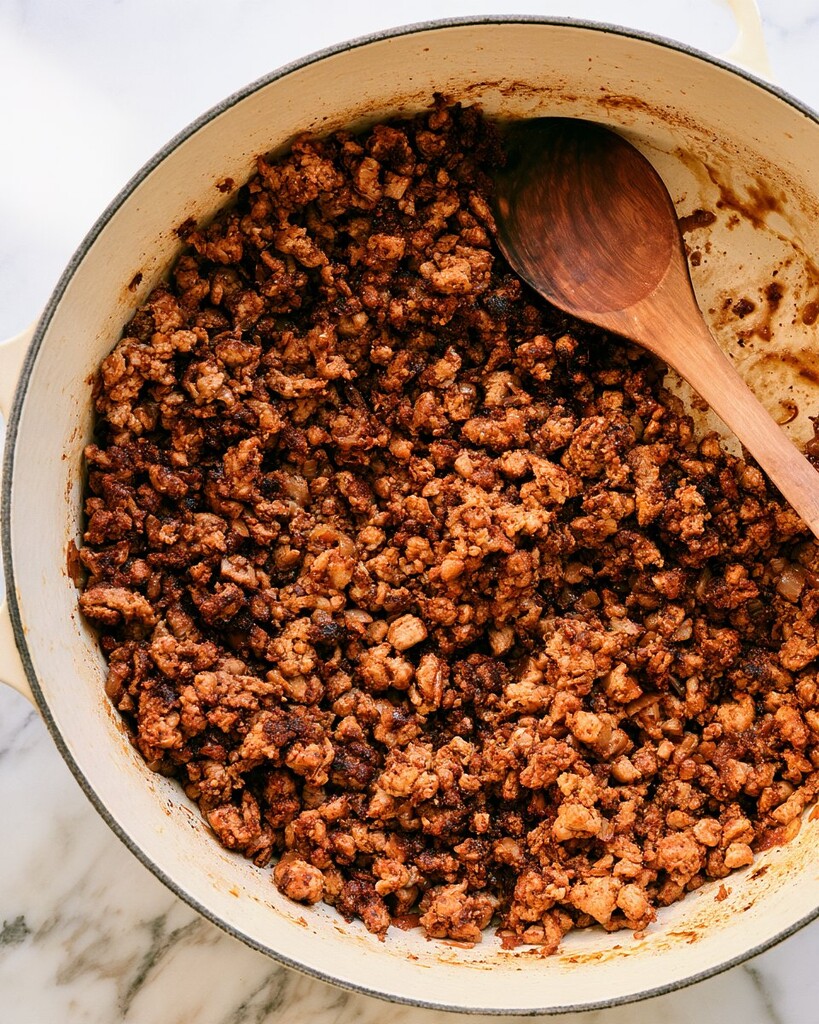 Ground turkey browning with diced onions in a heavy-bottomed Dutch oven