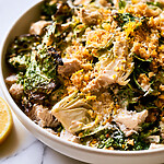 Charred cabbage and chopped chicken Caesar in a white bowl topped with golden panko and lemon zest