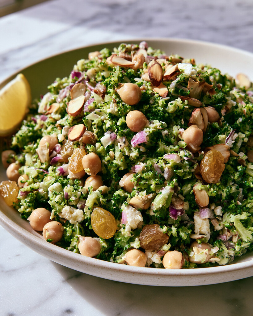 Chopped broccoli and chickpea salad tossed with hot honey dressing in a shallow serving bowl.