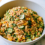 Deep bowl of crispy rice salad topped with mango, cucumber, and fresh cilantro