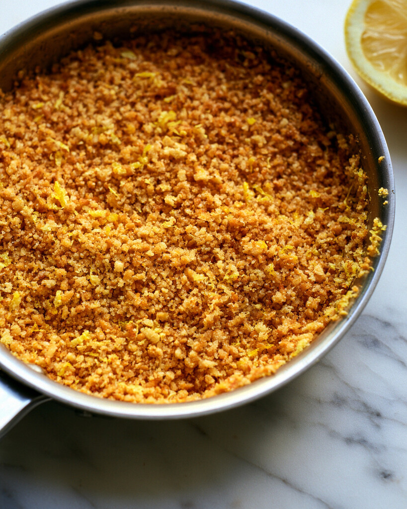 Golden panko breadcrumbs and fresh lemon zest toasting in a metal skillet
