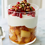 A completed pear yogurt parfait in a clear glass showing distinct layers of fruit and yogurt