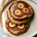 Stacked cottage cheese pancakes with glossy golden caramelized banana slices baked into the surface