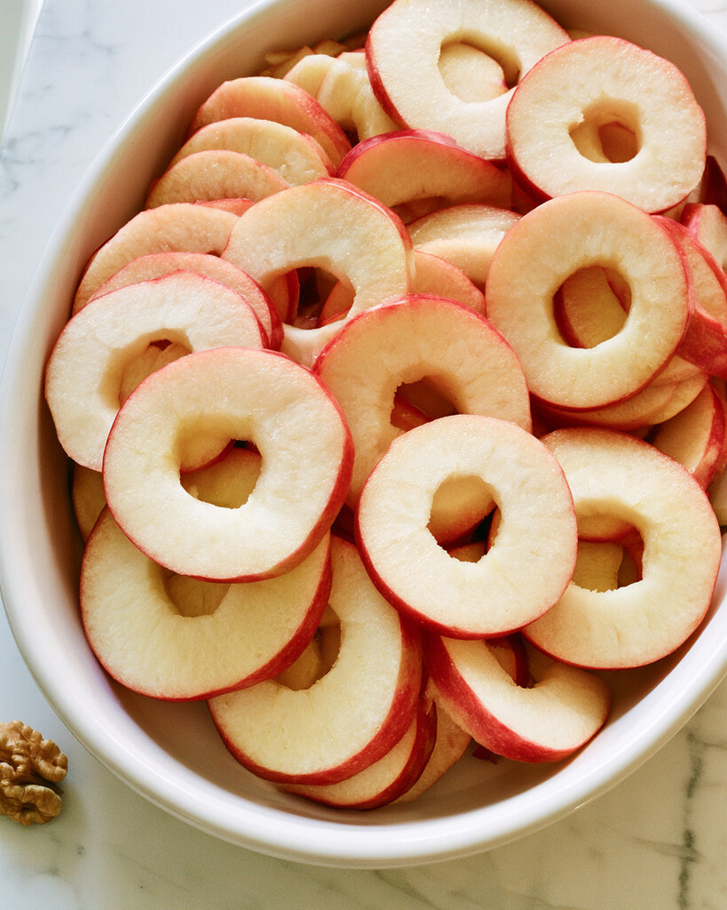 Red apple slices arranged horizontally in an overlapping circle on a white platter