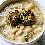Creamy Sheet-Pan Charred Broccoli & White Bean Soup Bowl of thick sheet-pan charred broccoli and white bean soup topped with dark roasted florets and potato cubes